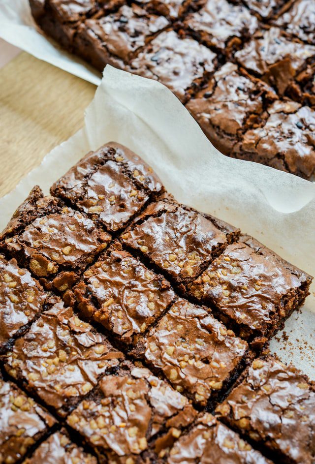 freshly baked brownies cut and placed on parchment paper