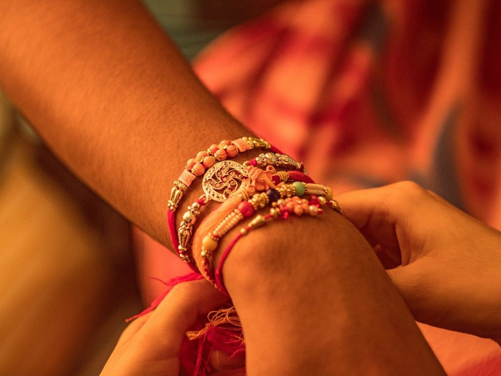 sister tying rakhi on her brother's hand