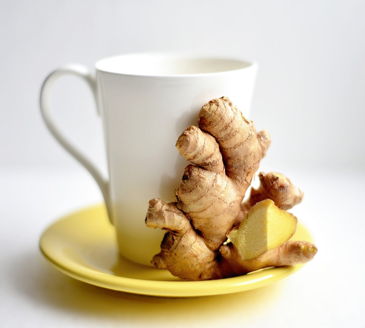 ginger kept in a yellow tea plate with a white tea mug