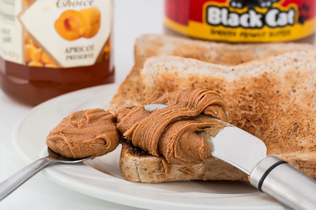 peanut butter is being spread on slices of bread