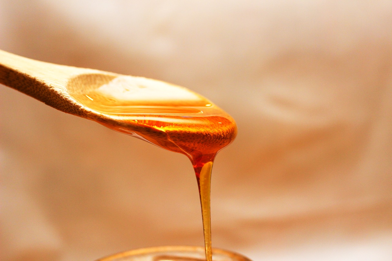 honey falling from a wooden spoon