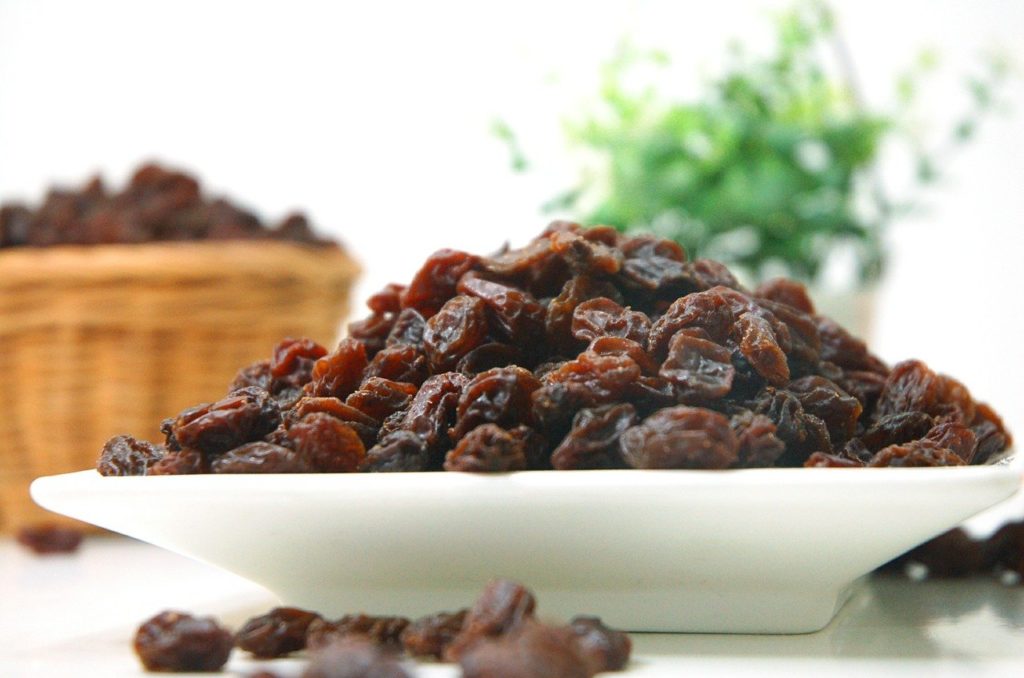 black raisins kept on a white bowl