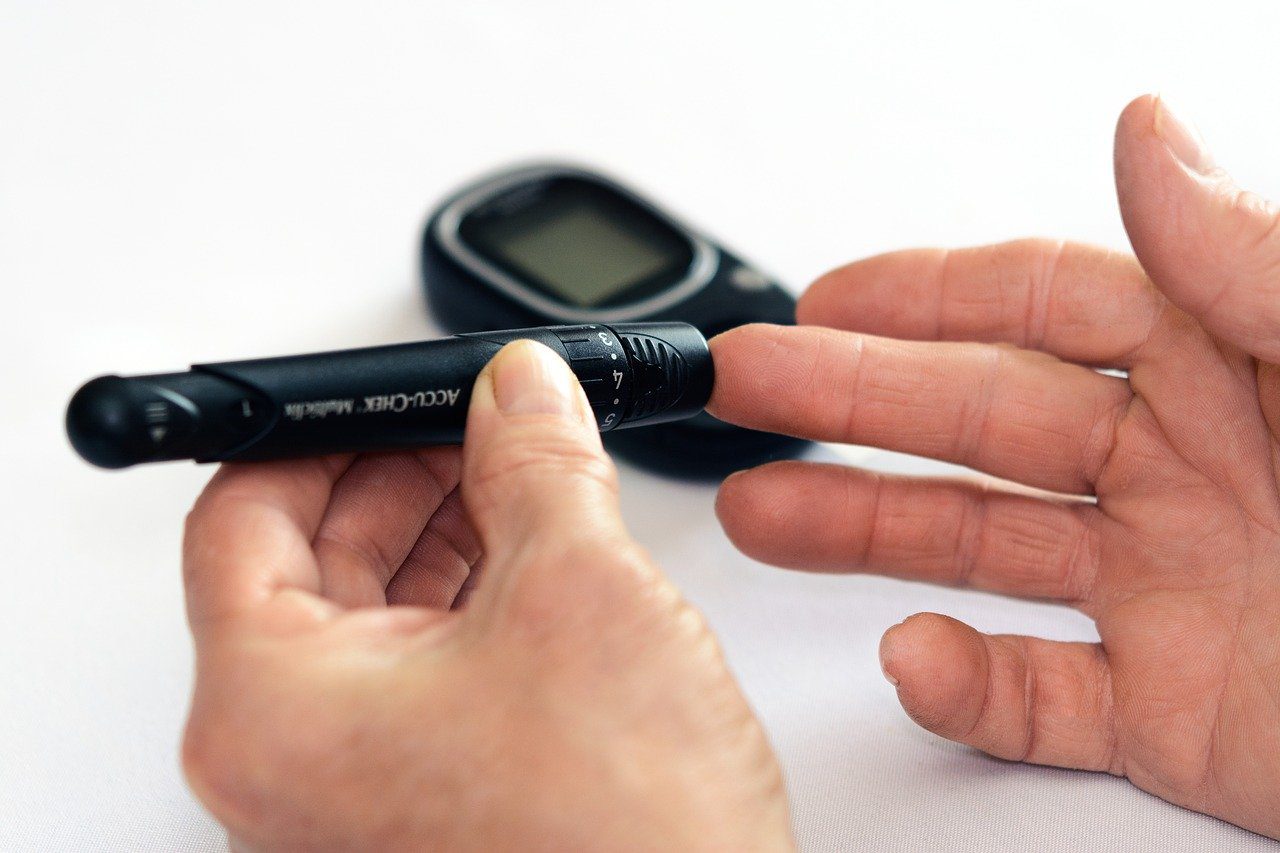 a person checking blood sugar with a diabetics checking machine