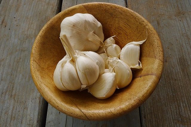garlic cloves in a small wooden bowl