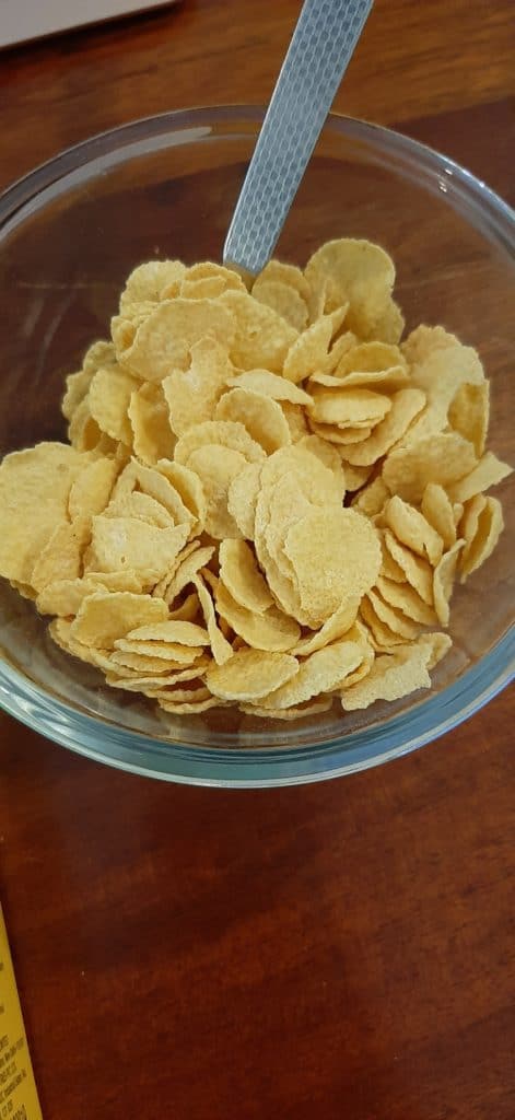 nestlé nesplus crunchy flakes in a transparent glass bowl with a spoon