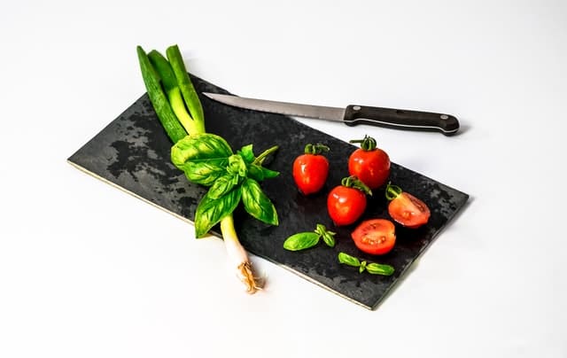 chopping board with vegetable and knife on top of it.