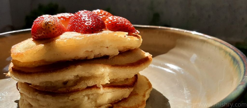pancakes topped with fresh strawberries and honey