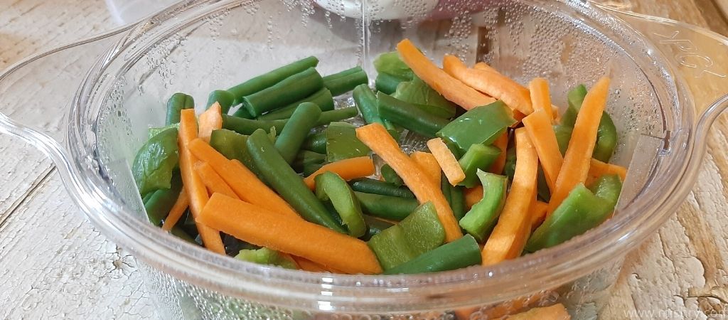 chopped beans and carrots in steaming basket