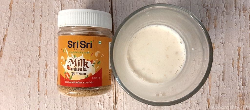 overhead look at srisri tattva milk masala in a glass after mixing with hot milk