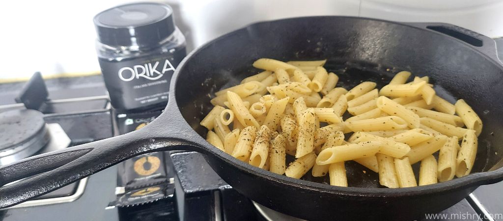 orika italian seasoning added to pasta in a pan