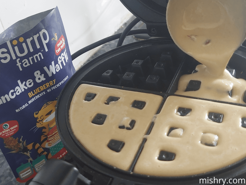 the waffle being made using the slurrp farm blueberry pancake & waffle mix