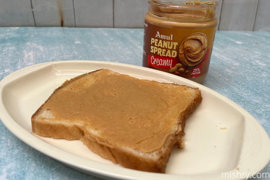amul peanut spread creamy applied on a slice of toasted bread